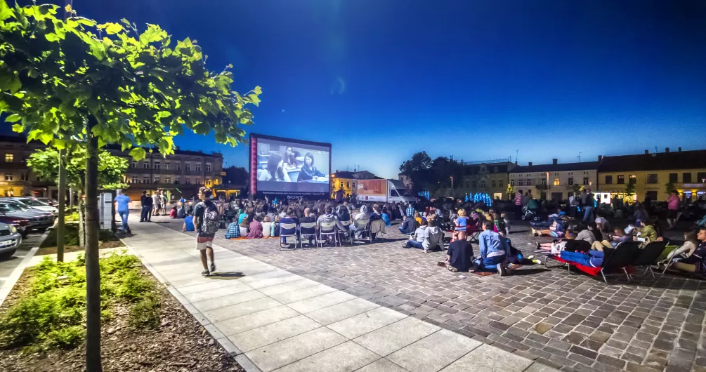 Zdjęcie przedstawia ludzi oglądających kino na pl. Kościuszki